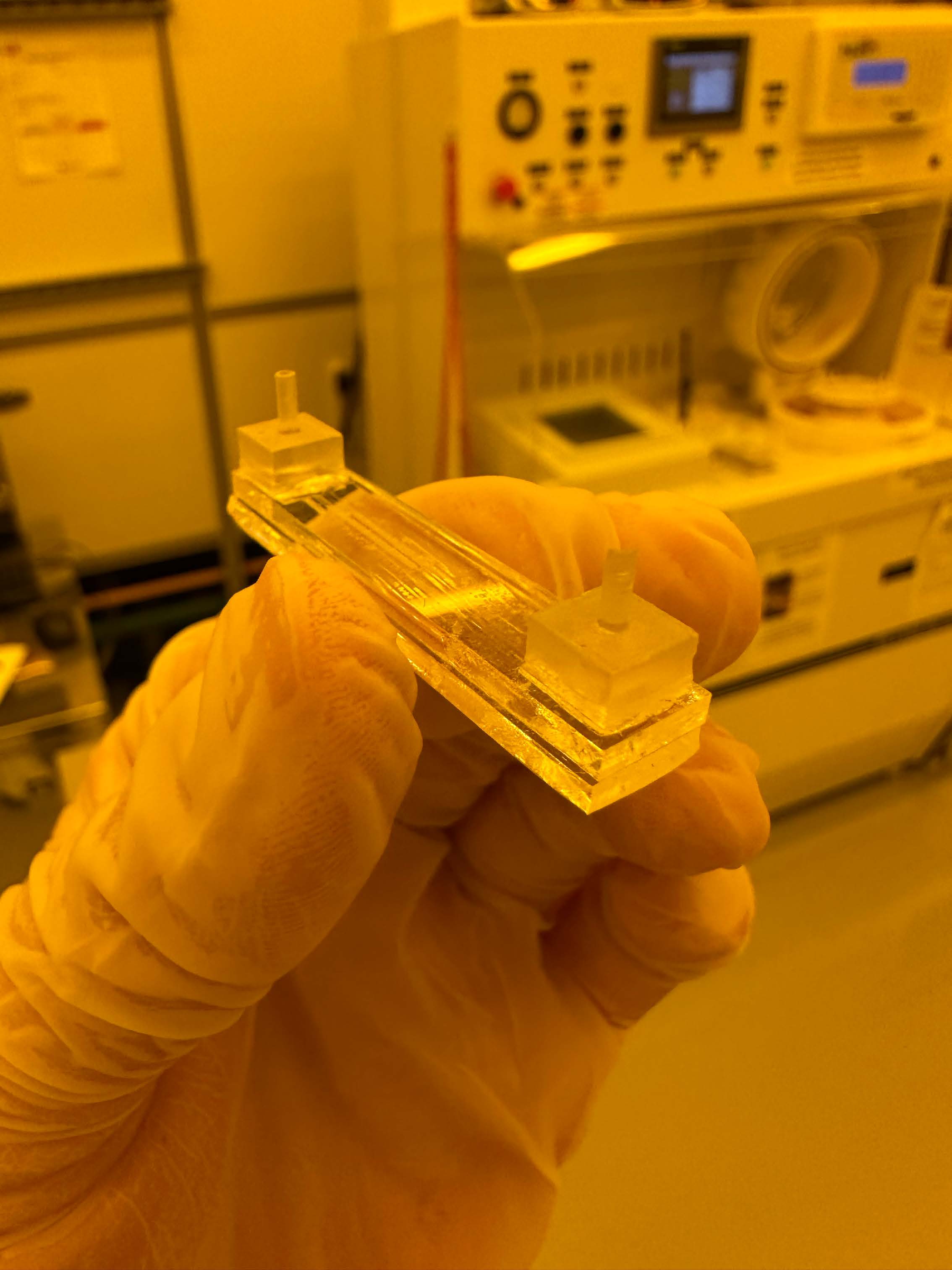 Bonded flow cell held by a gloved hand in the cleanroom
